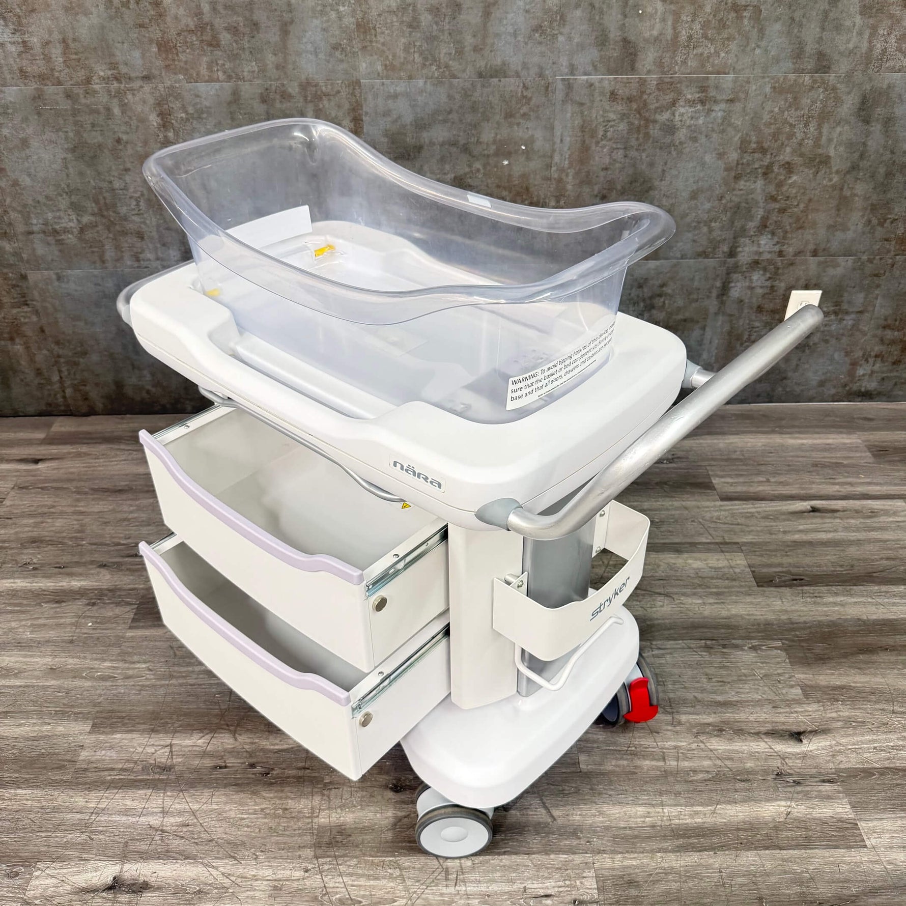 Side angle of Stryker hospital baby bassinet with wheels - for sale